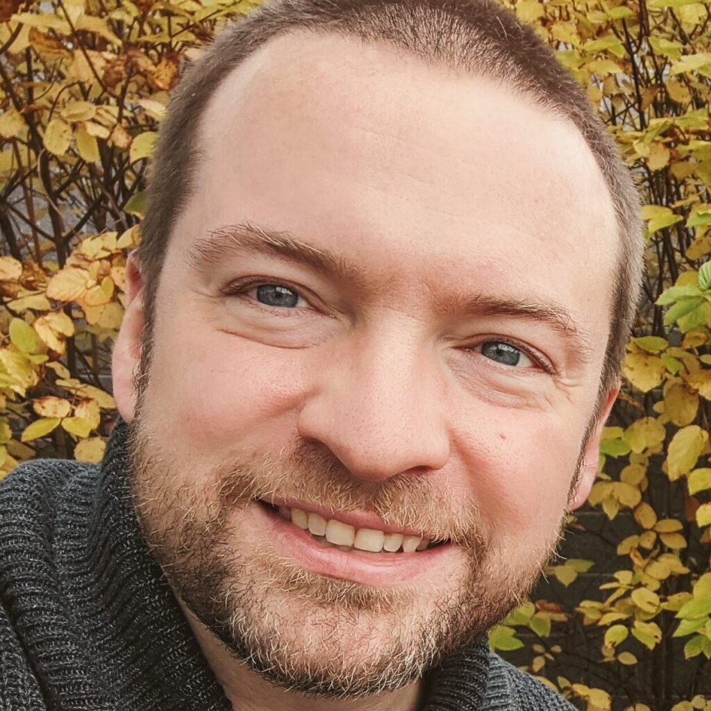 A headshot of Justin Maciejewski.